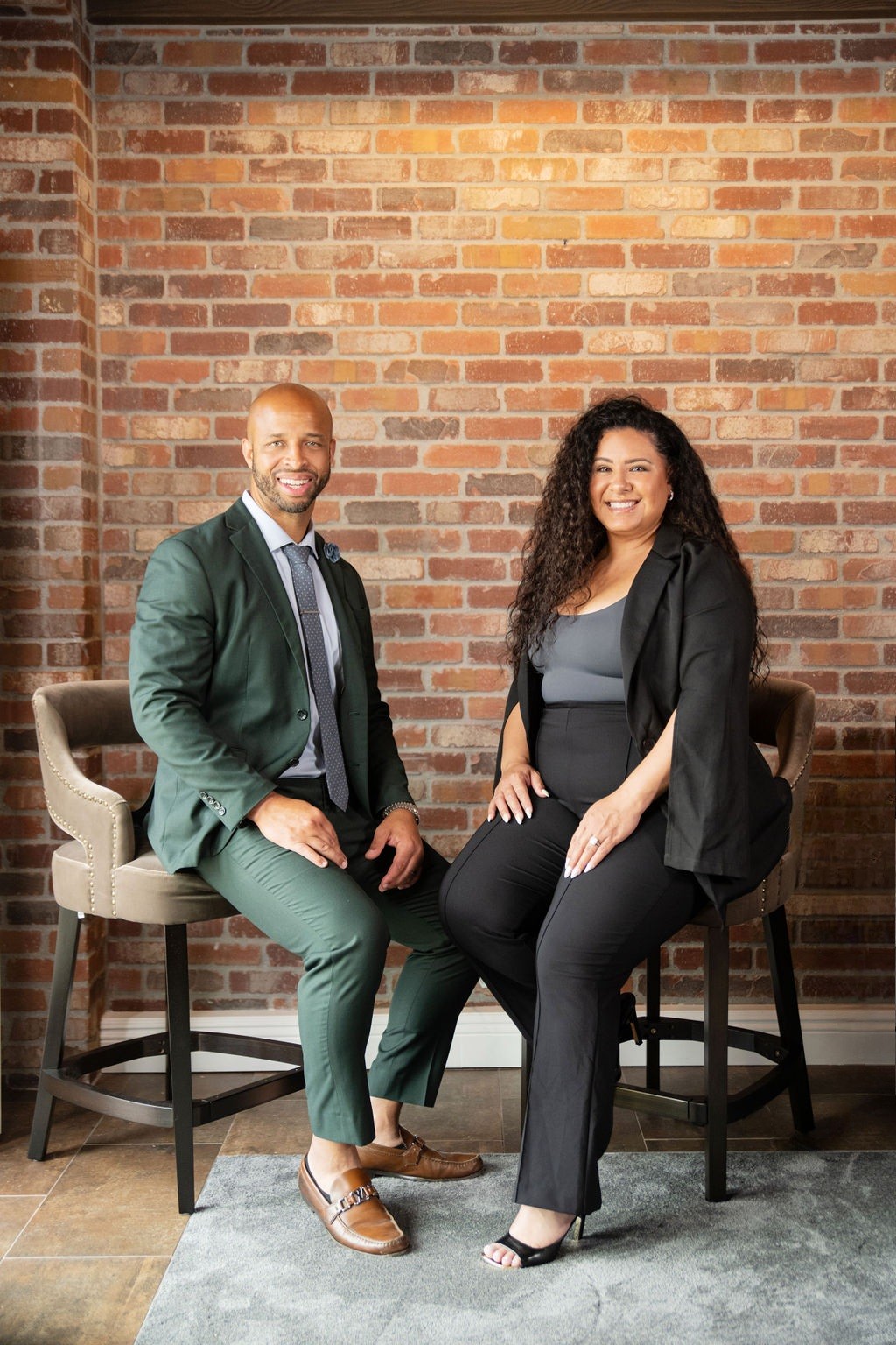 True Vision Enterprises professionals — a man and woman posing confidently against a brick wall